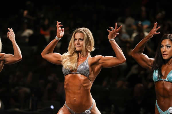 Amy Koop, 30, number 67, centre, competes in the physique Open category on stage at the Henderson Thorne Natural Classic on Saturday, July 12, 2015 in Hamilton. The trend is for women, juggling kids and jobs to enter the world of bodybuilding. Glenn Lowson photo for The Globe and Mail
