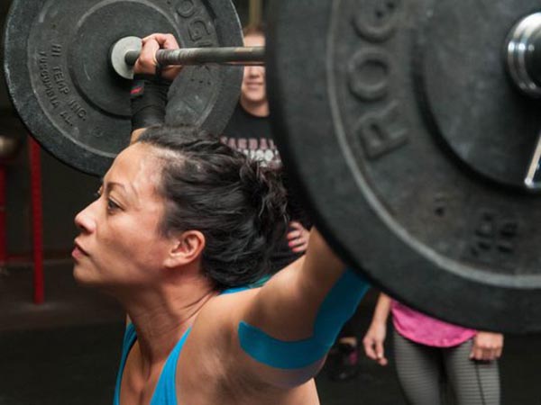 Gee Gee Pabellon of Las Cruces lifts moderate weight to warm up at Crossfit Las Cruces. Pabellon said lifting weights has helped her gain strength and confidence and set an example for her two children that women can be strong, too. 