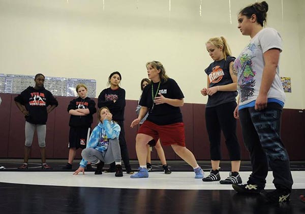 Tornados girls wrestling coach Amy Earley, center, demonstrates some wrestling moves with her team at a practice Dec. 29 at Yelm High School. Cassie Virgil, second from right, stopped by to lend a hand during the practice.